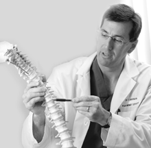 Doctor Harman examines a model of a human spine